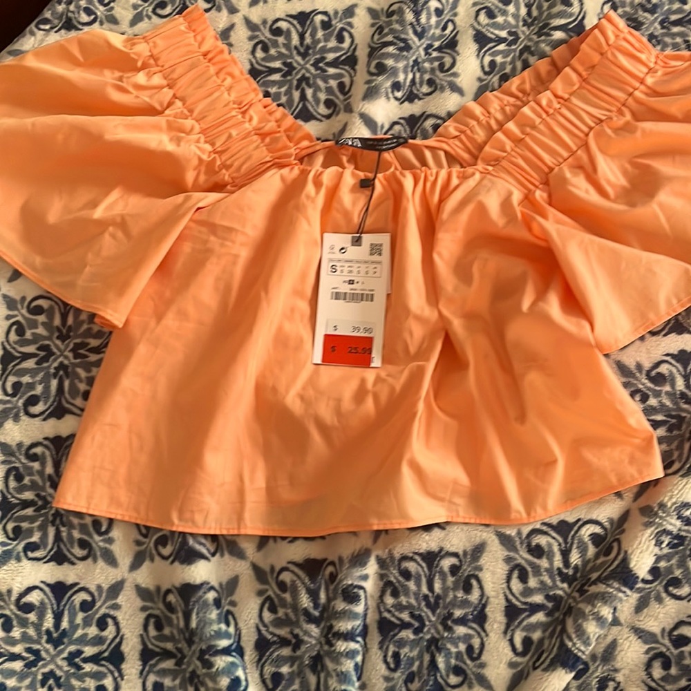 Pastel orange/peach puffy ruffles and puffy short sleeved shirt. Size small :)